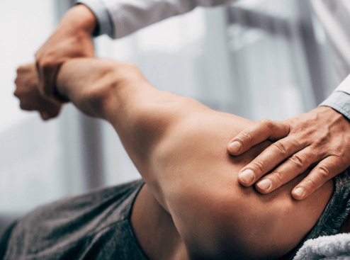 A man is getting his arm massaged by a wellness doctor.
